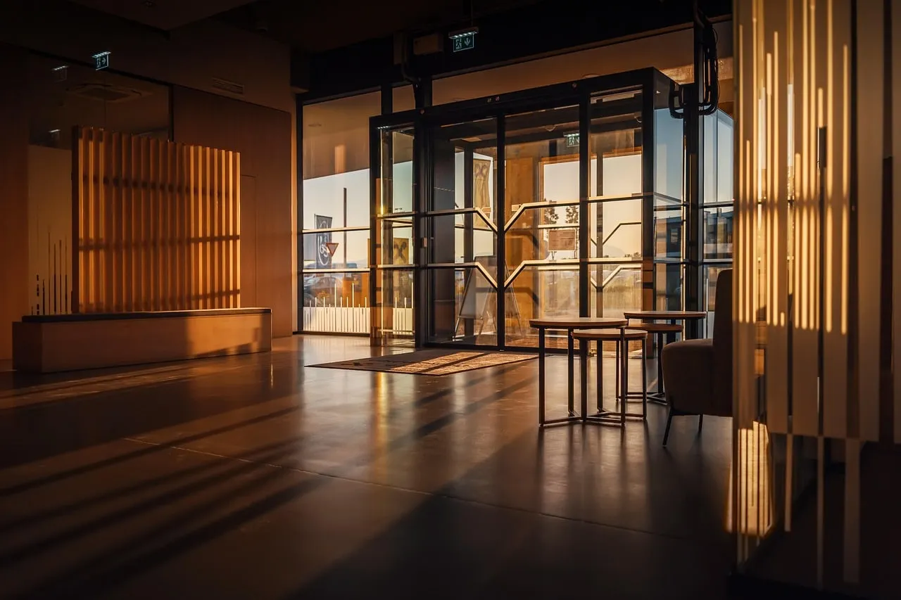 A timber-lined entrance lobby lit after dark.