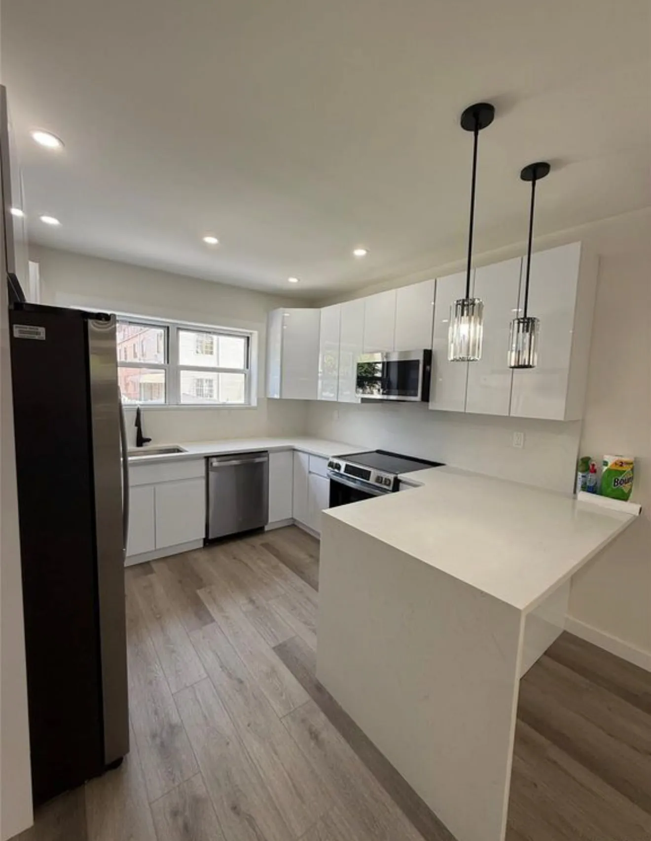 Kitchen with a full-height stone return and a seated end to the counter.