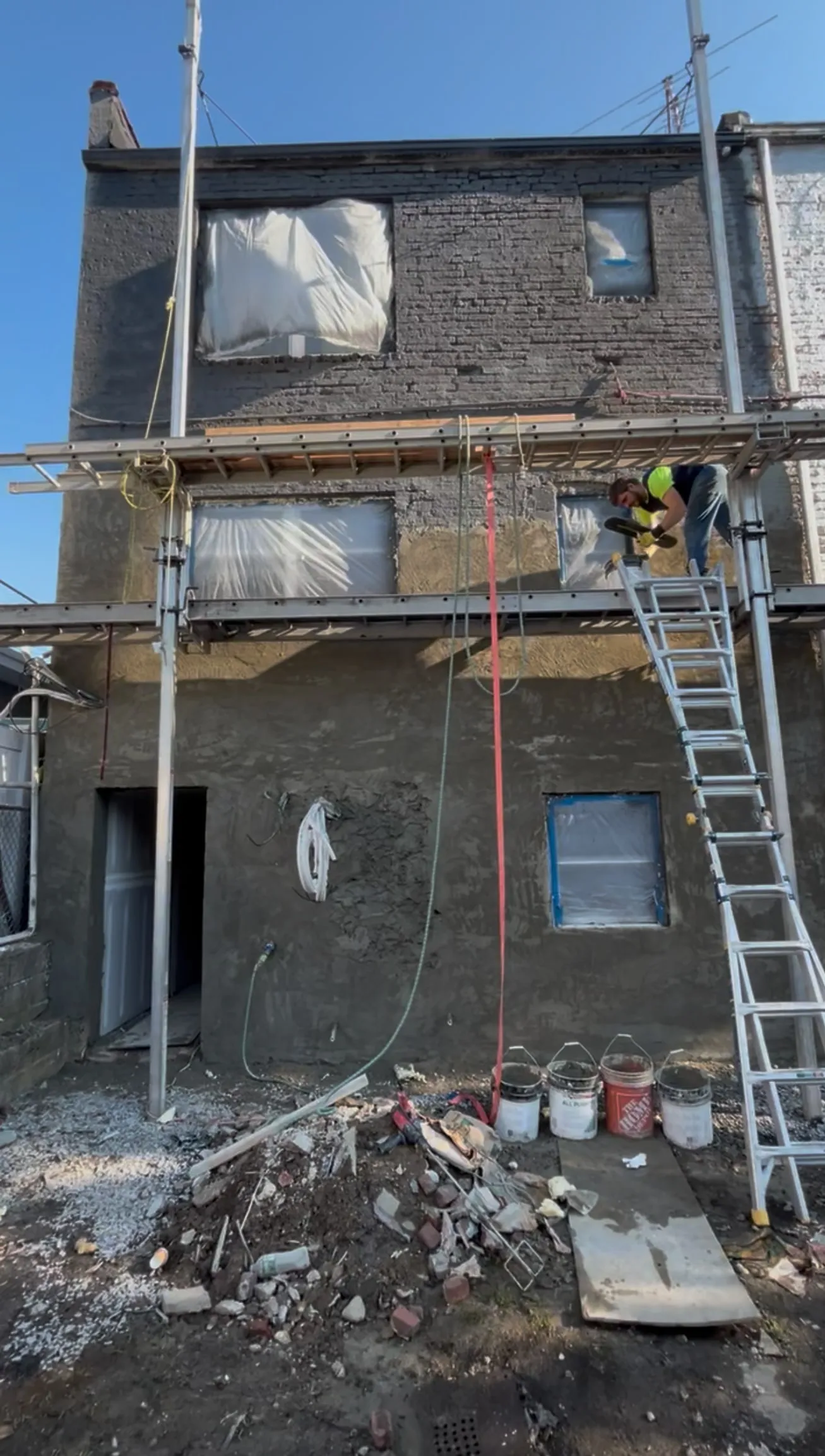 The render going on, worked down the elevation one lift at a time.