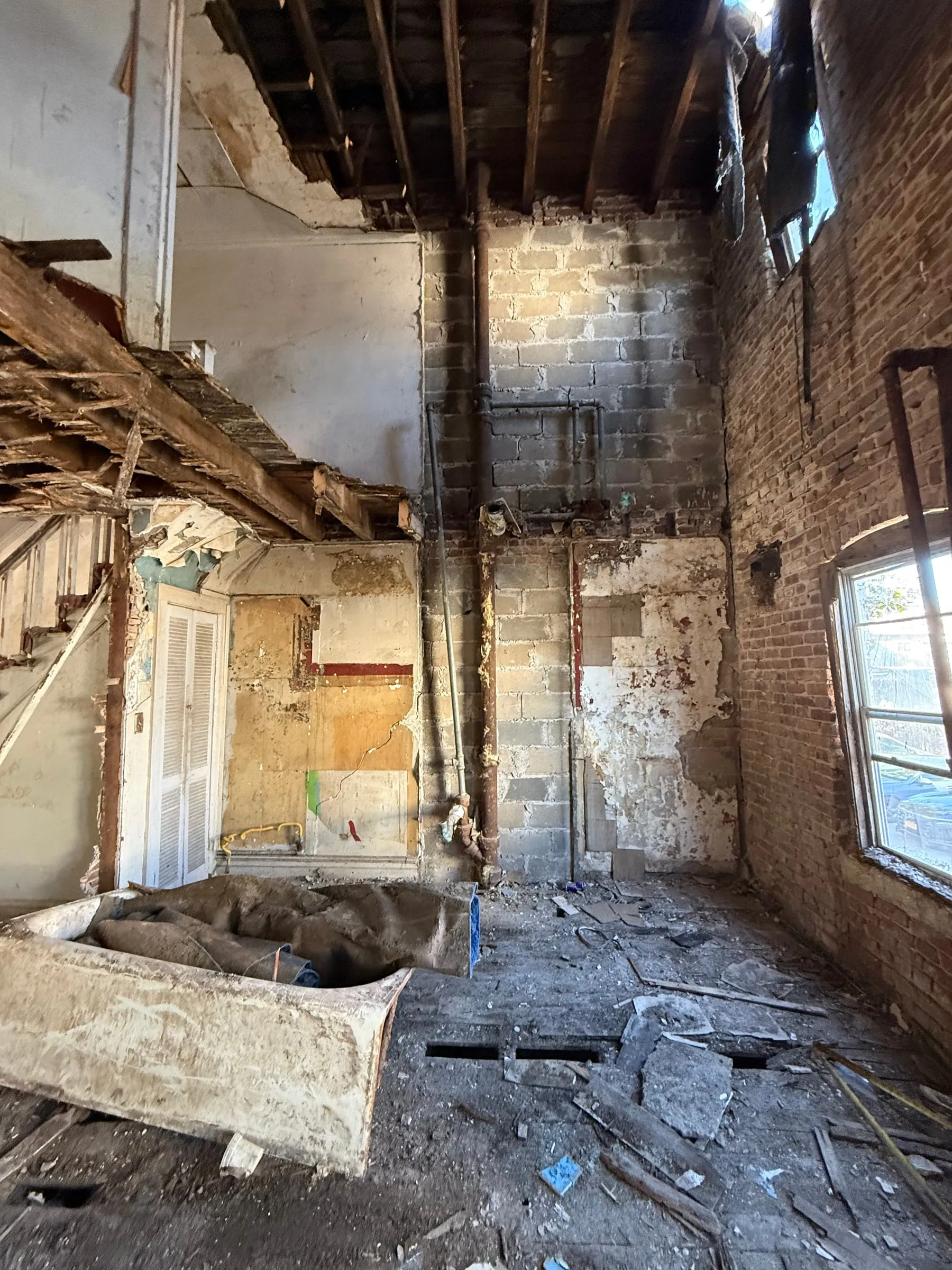 The ground floor, back to bare brick and block with the ceiling opened up.