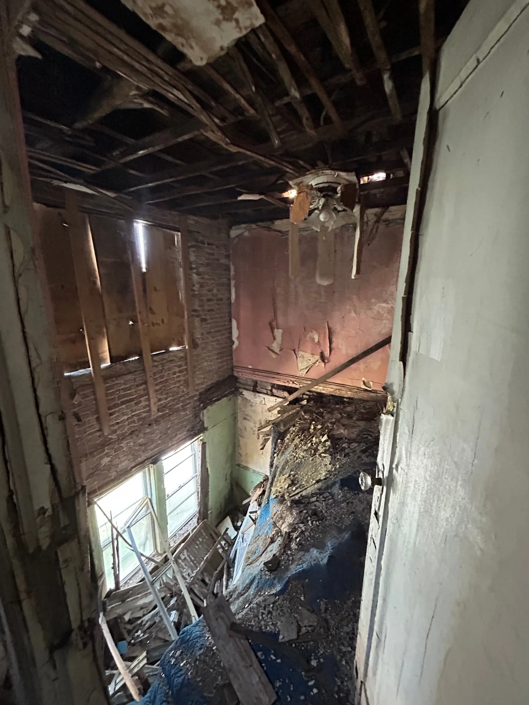 Down through the stair void, with the roof structure exposed above it.