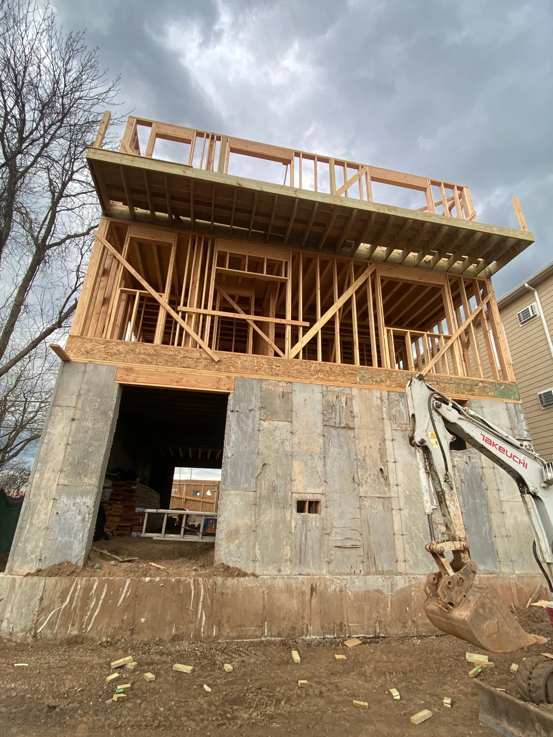 From the low side of the lot, where the foundation carries a full storey.